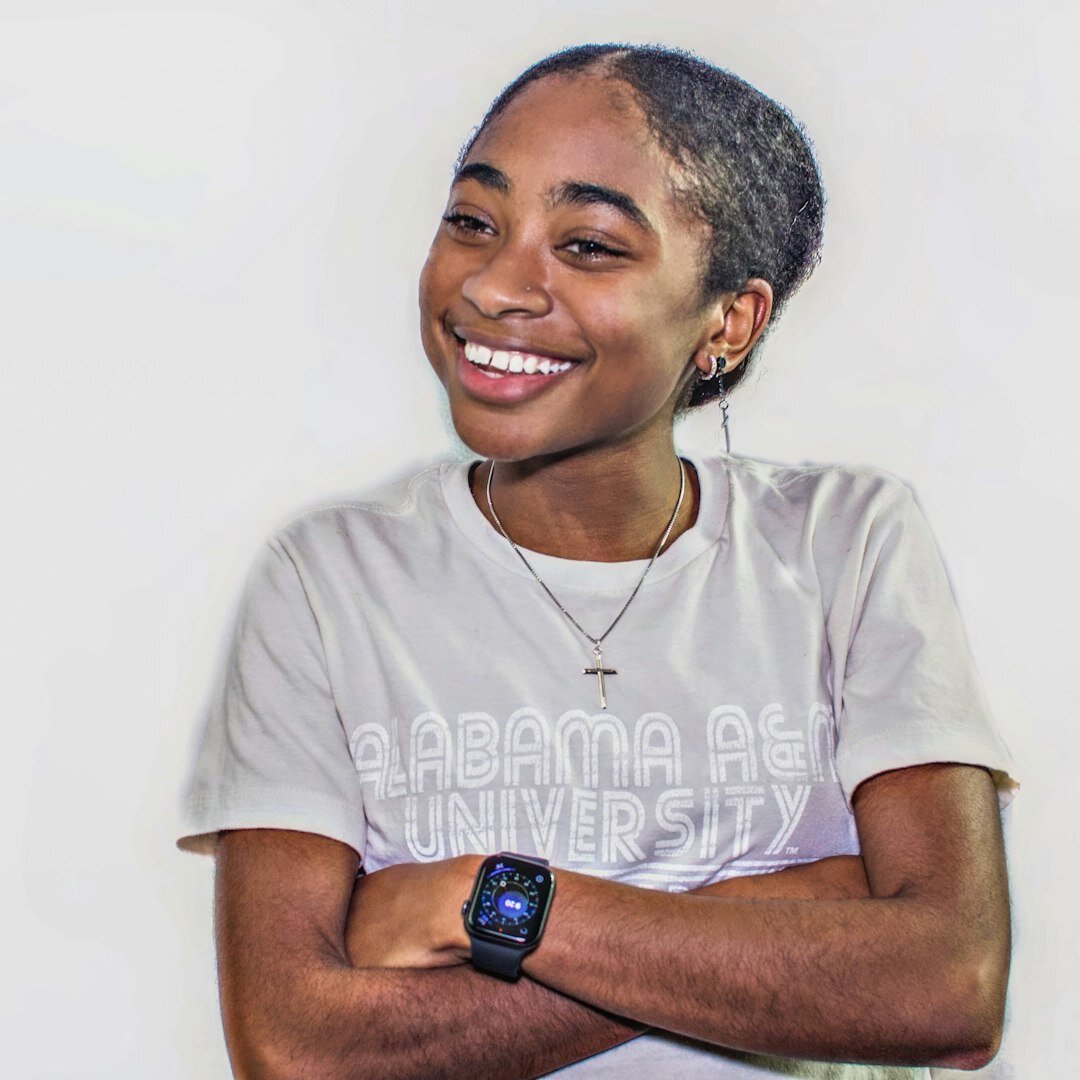 Studio portrait of a smiling Afro-Brazilian woman with braided hair
